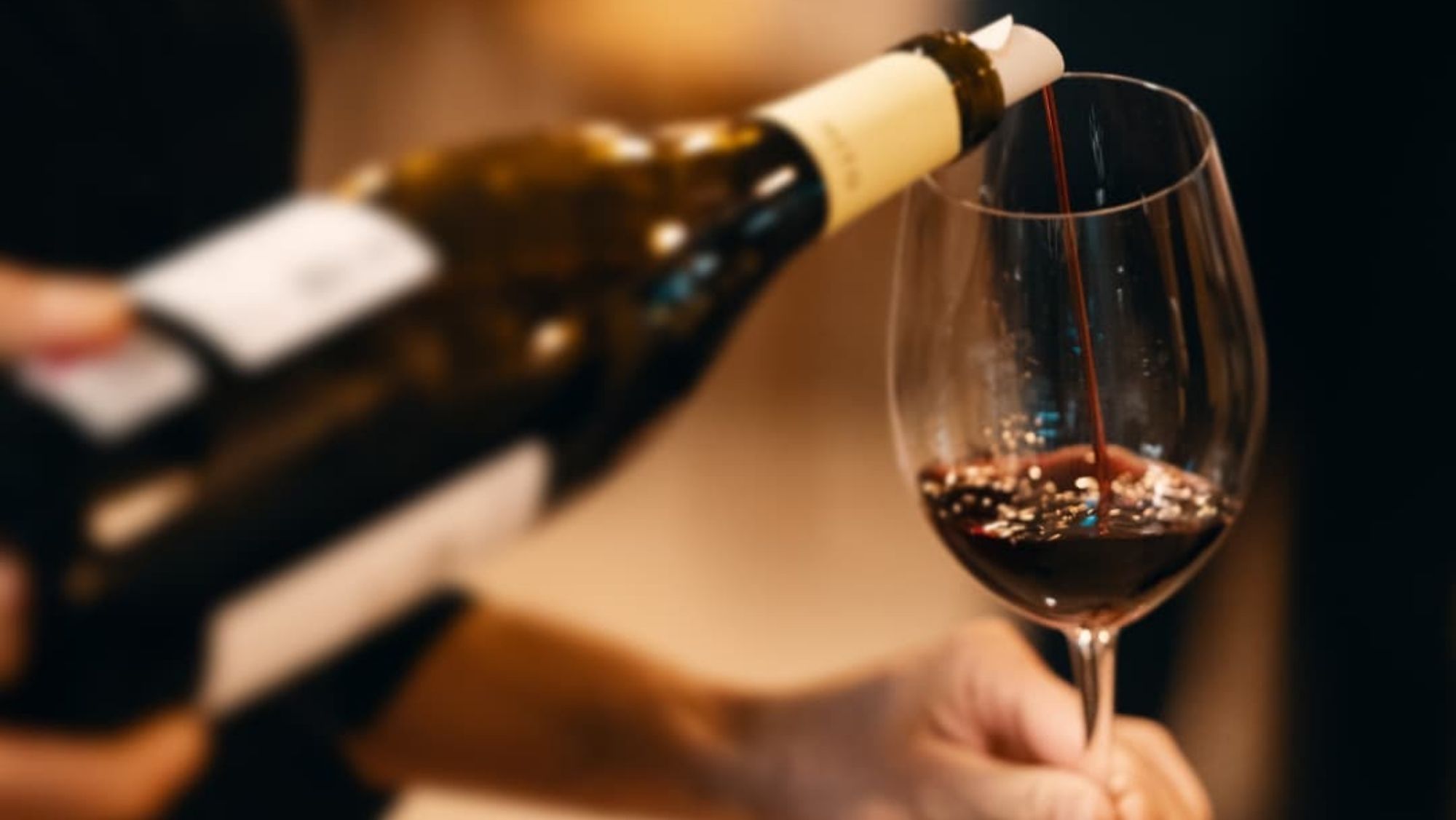 Copa de vino servida desde una botella de Ribera del Duero / @riberadelduero