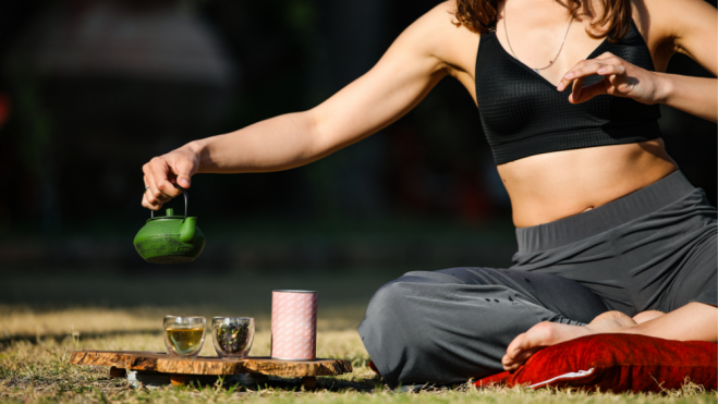 Mujer tomando té antes de iniciar una sesión de yoga. / Foto: Canva