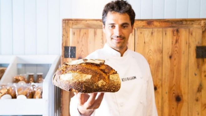 El maestro panadero Xevi Ramon sostiene una hogaza de pan en su obrador / Foto: Triticum