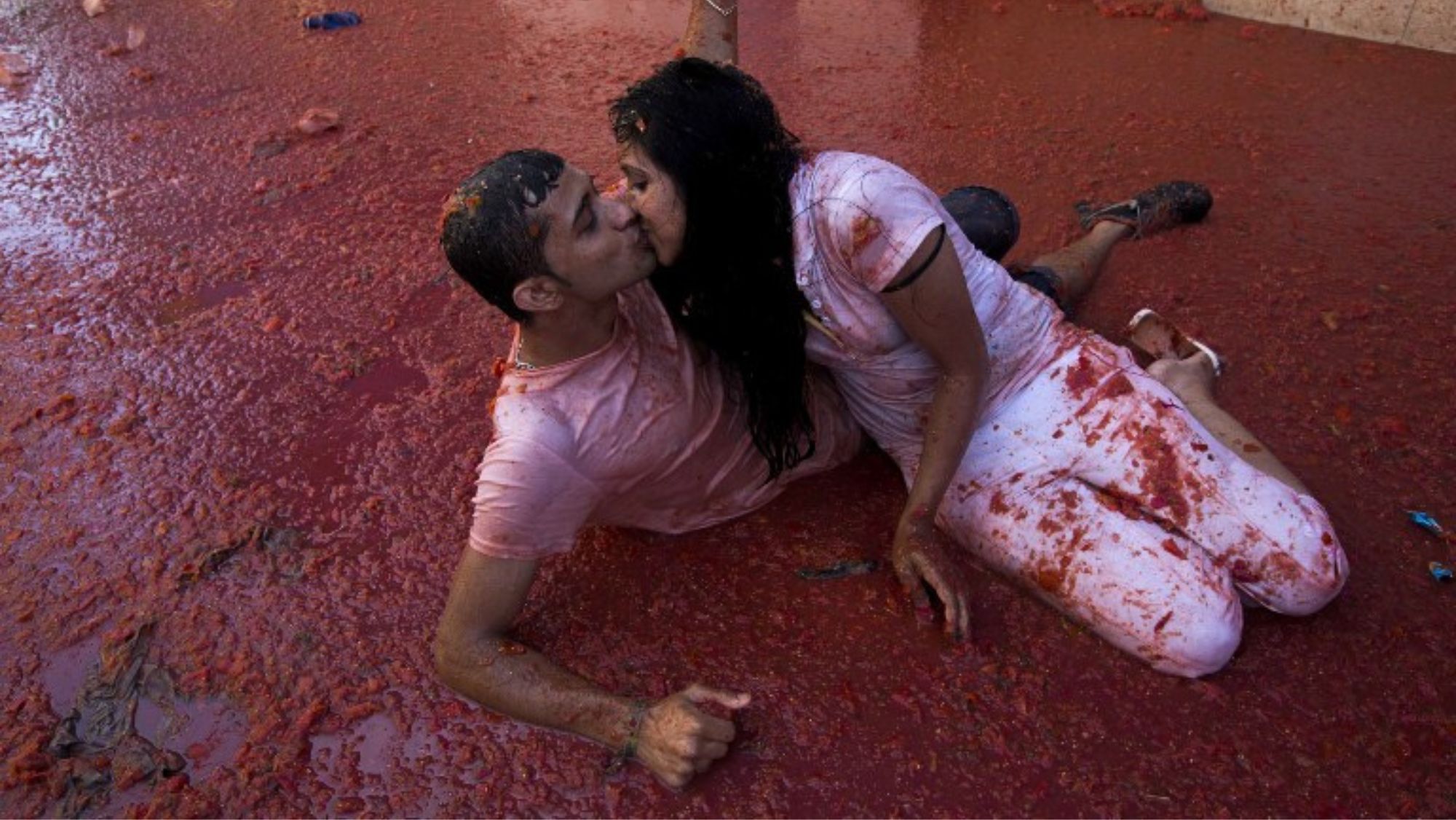 Una pareja se besa en el suelo de Buñol durante La Tomatina / Foto: AFP PHOTO Gabriel Gall vía Flirck (CC BY 2.0)