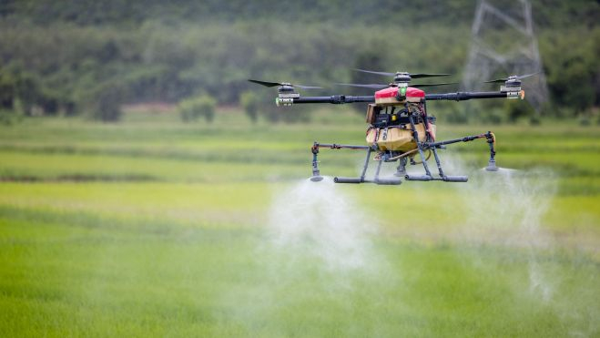 Dron esparciendo fertilizantes en un campo / Foto: Canva