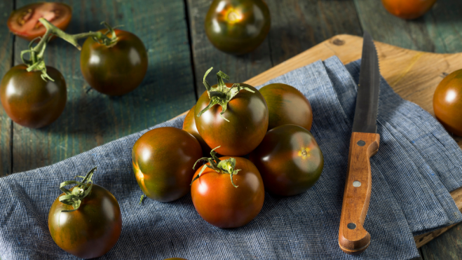 Tomates kumato sobre bandejas de madera / Foto: Canva