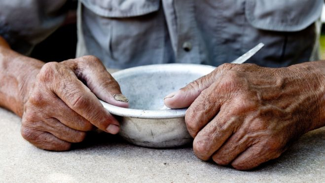 Un hombre sostiene un plato vacío / Foto: Canva