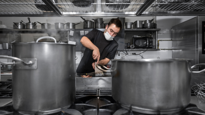 Cocinero trabajando en una cocina industrial / Foto: Canva