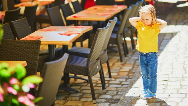 Niña de pie en la terraza de un restaurante / Foto: Canva Niña de pie en la terraza de un restaurante / Foto: Canva