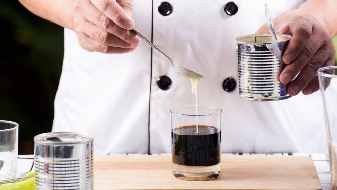 Chef poniendo leche condensada en un vaso de café / Foto: Canva Chef poniendo leche condensada en un vaso de café / Foto: Canva