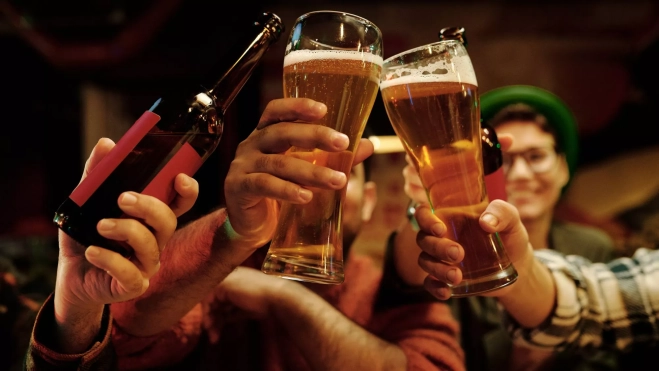 Un grupo de personas brindando con cerveza / Foto: Canva