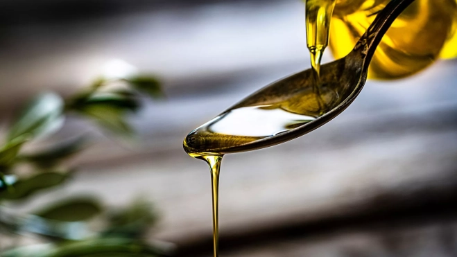 Hilo de aceite de oliva sobre una cuchara / Foto: Canva