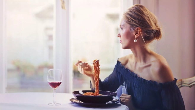 Mujer comiendo sola en un restaurante / Foto: Canva