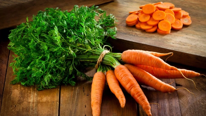 Manojo de zanahorias y zanahoria cortada a rodajas / Foto: Canva