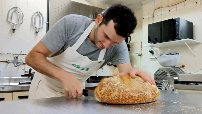Gerard Gil cortando el pan en el obrador / Foto: Òscar Gómez