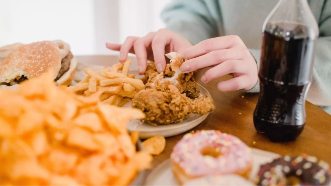 Mesa con distintos platos de comida rápida y dulces / Foto: Pexels