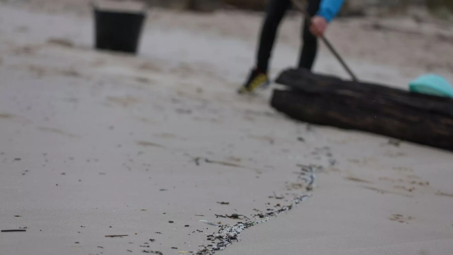 Retirada de pellets en la playa de Muros (A Coruña) / Foto: EFE / Sxenick