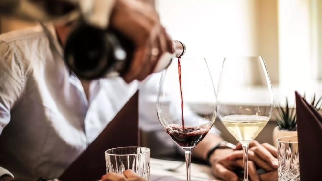 Camarero sirviendo vino en un restaurante / Foto: Canva