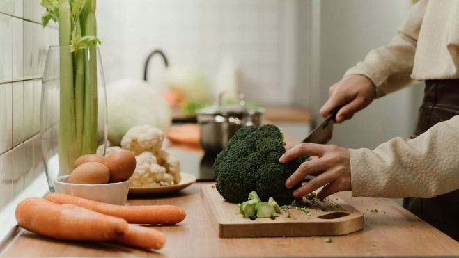 Cocinero cortando brócoli y otras hortalizas / Foto: Canva