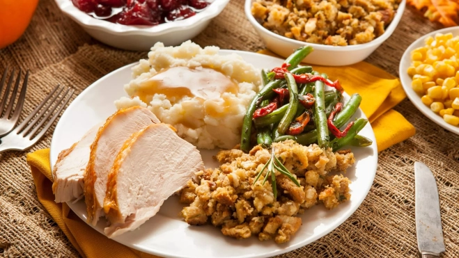 Pavo cortado y servido junto con el resto de platos de Acción de Gracias / Canva Pavo cortado y servido junto con el resto de platos de Acción de Gracias / Canva