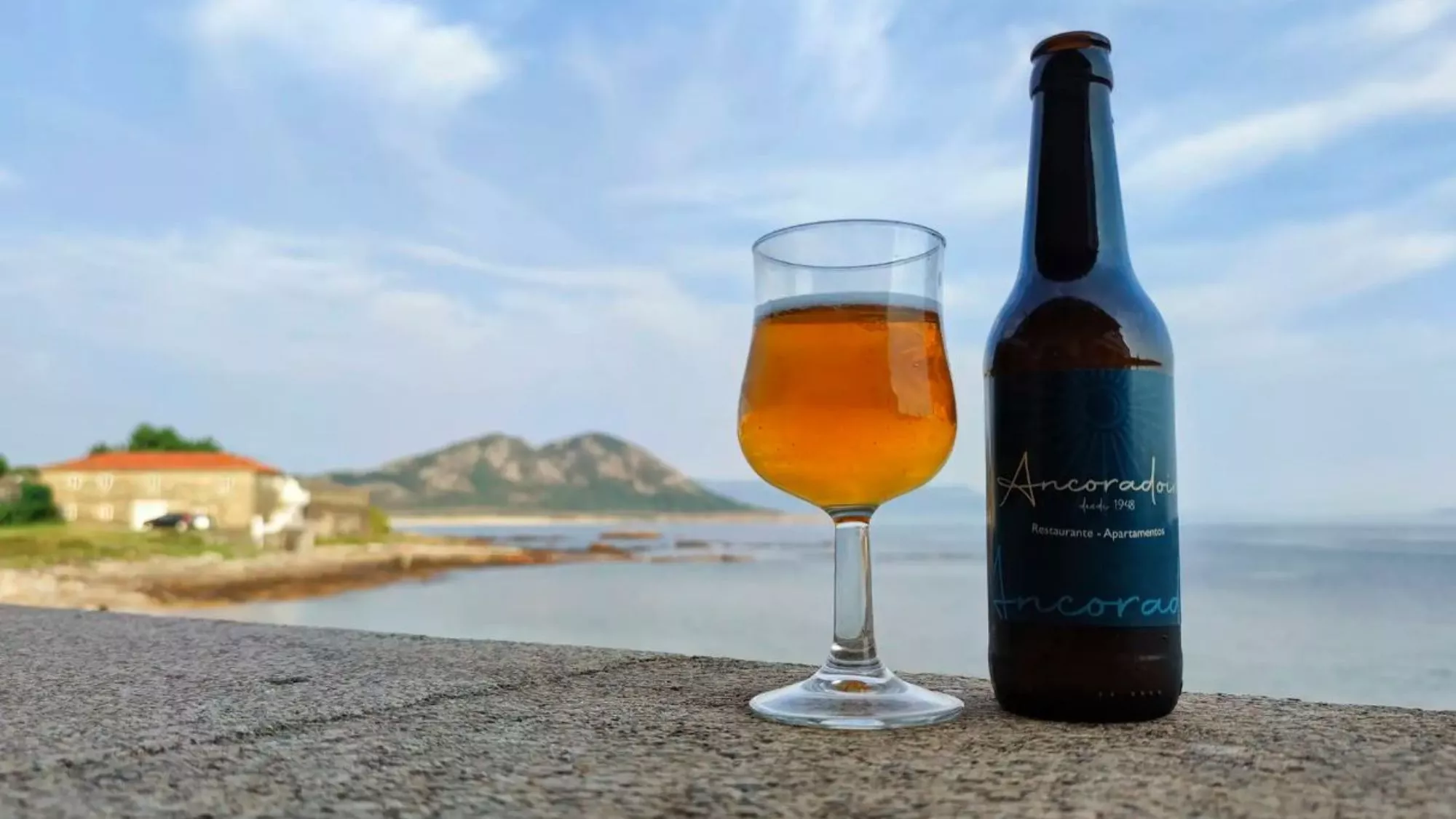 Copa de cerveza con vistas desde el restaurante Porto do Ancoradoiro (Louro) / Instagram / Dónde comer en la Costa da Morte: chiringuitos, restaurantes y una tienda donde apurar el verano
