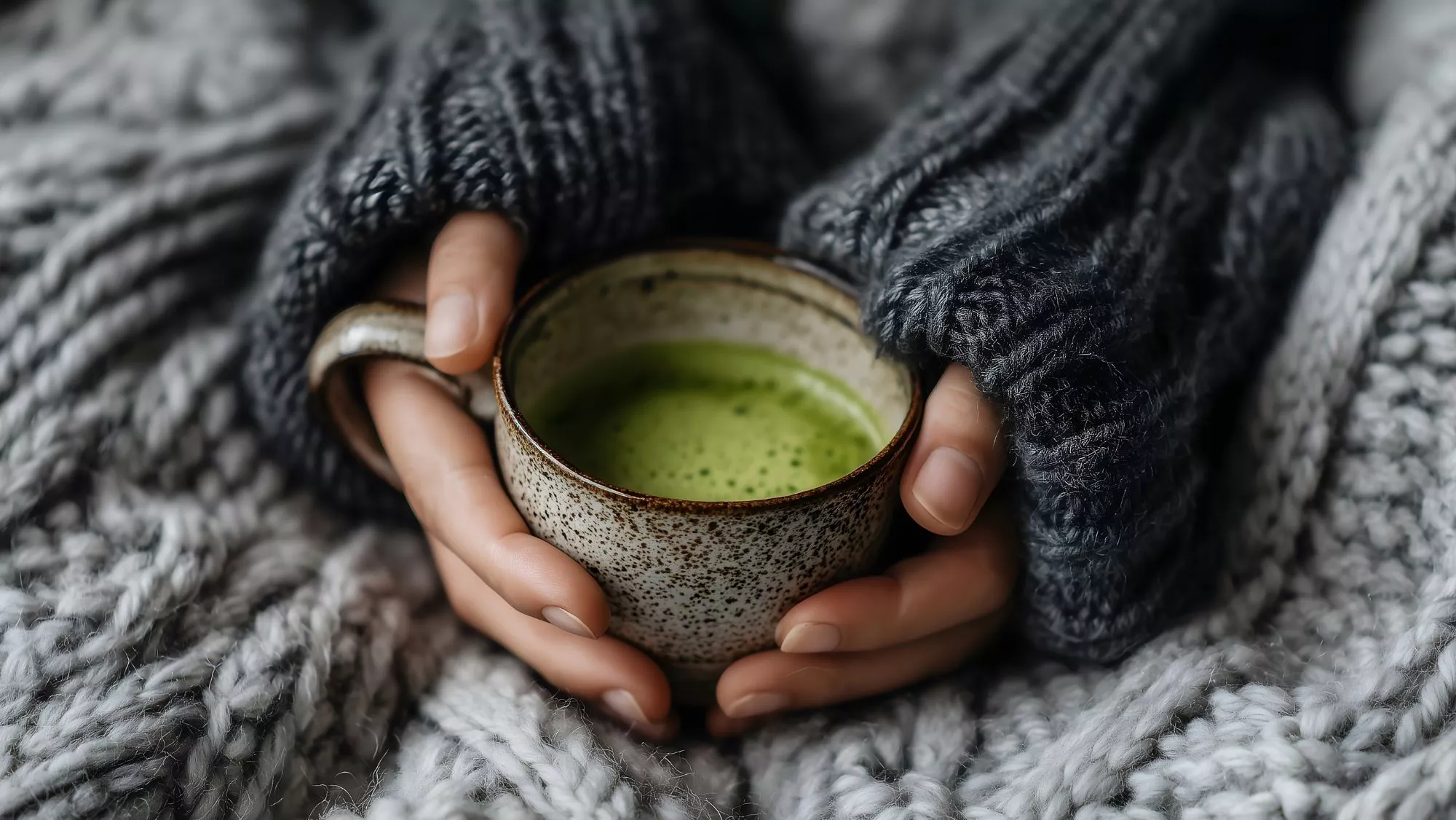 Mujer sosteniendo una taza de té matcha / Canva
