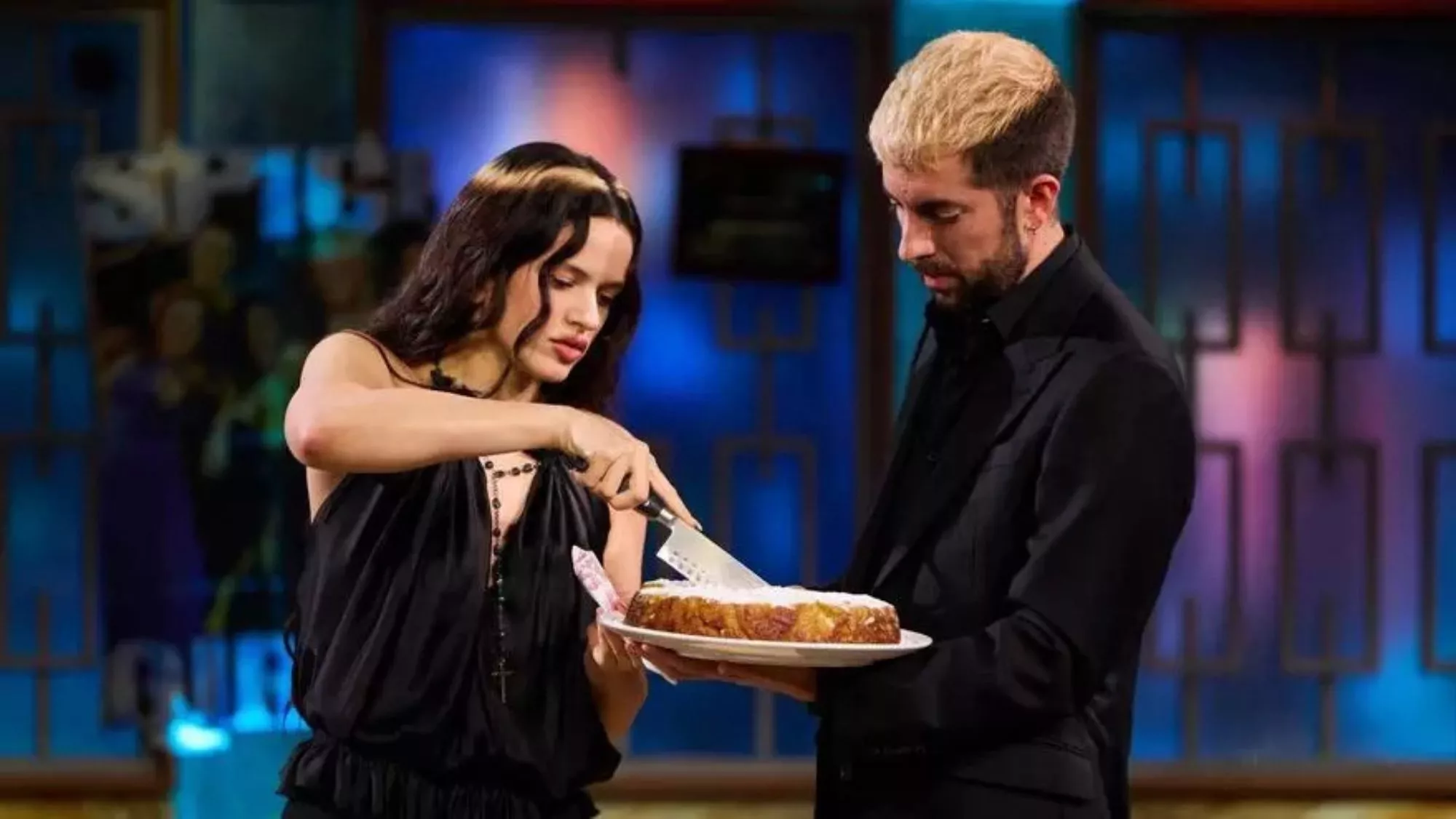 Rosalía corta el bizcocho de aceite de oliva y naranja delante de David Broncano en 'La Revuelta' / RTVE