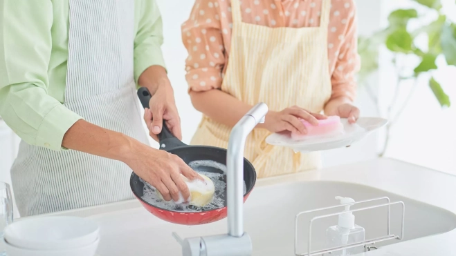Limpieza de sartén y platos en una cocina doméstica / Canva Limpieza de sartén y platos en una cocina doméstica / Canva