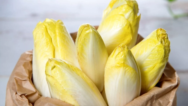 Bolsa de papel llena de endivias / Canva