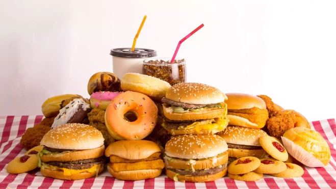 'Fast food' o 'comida basura' sobre una mesa / Canva