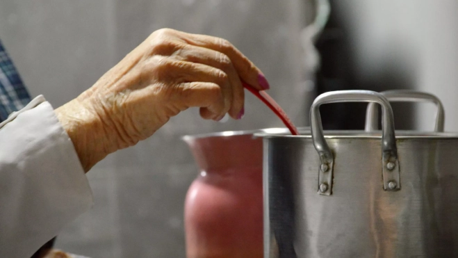 Mujer cocinando un guiso a fuego lento / Canva