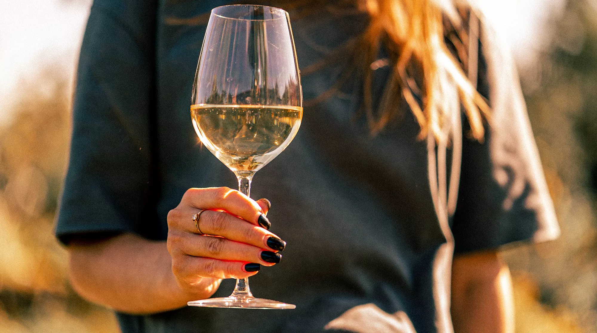 Joven con una copa de vino blanco / Envato / La tendencia del vino blanco, explicada en 8 vinos (más allá del albariño y el godello)