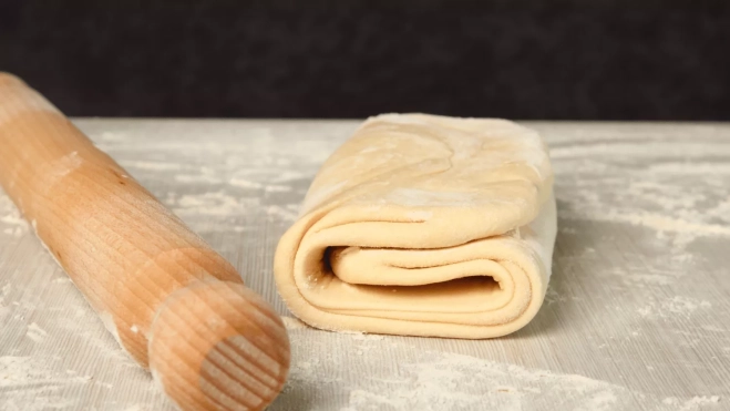 Masa de hojaldre con un rodillo de madera al lado / CANVA Masa de hojaldre con un rodillo de madera al lado / CANVA