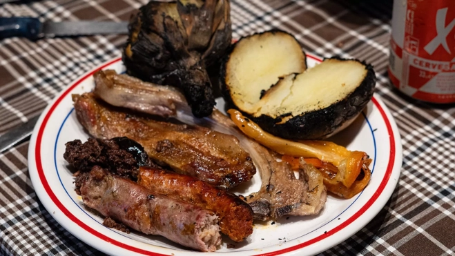 Plato de carne, patatas y alcachofa en una calçotada / Txaber Allué