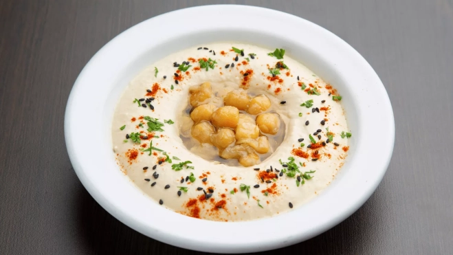 Plato de crema con garbanzos enteros en el medio / CANVA