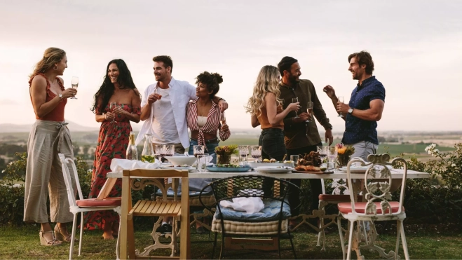 Grupo de amigos celebrando una comida al aire libre / Canva