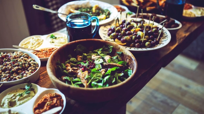 Ensaladas y algunos aperitivos para una comida con invitados / Canva