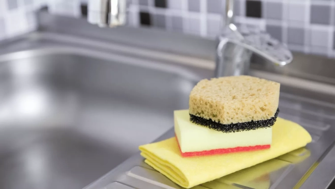 Estropajos y bayetas limpias al lado del fregadero / CANVA