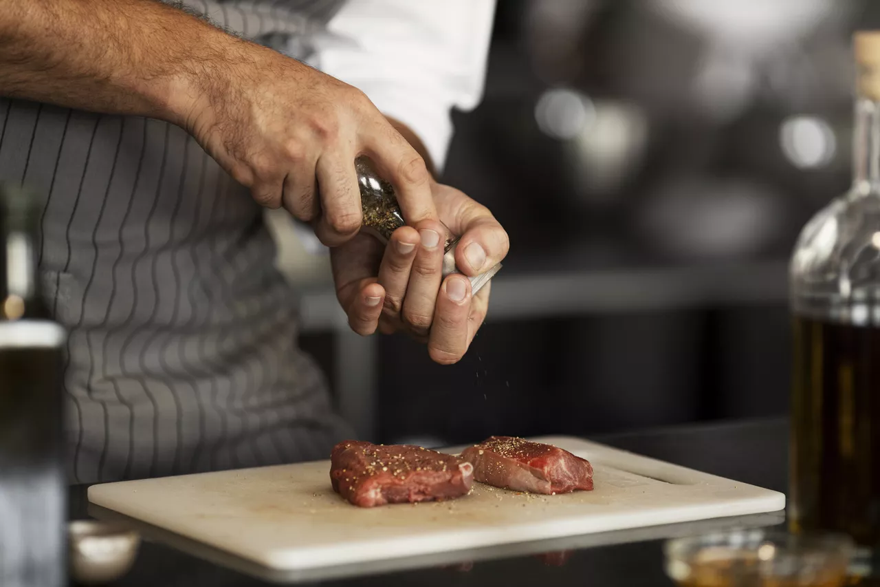 Chef sazonando unas piezas de carne