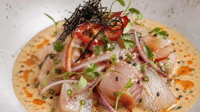 Preparación de ceviche Nikkei en un plato blanco | Canva
