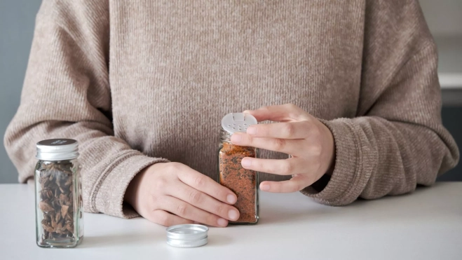 Mujer abriendo un recipiente de schichimi togarashi / Canva Mujer abriendo un recipiente de schichimi togarashi / Canva